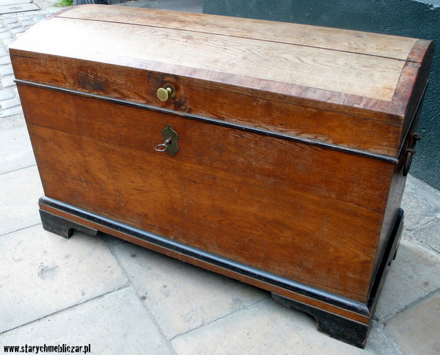 Kufer dębowy z końca XIXw. z okleinowaną orzechem ramką na wieku, wsparty na czterech konsolowych nogach